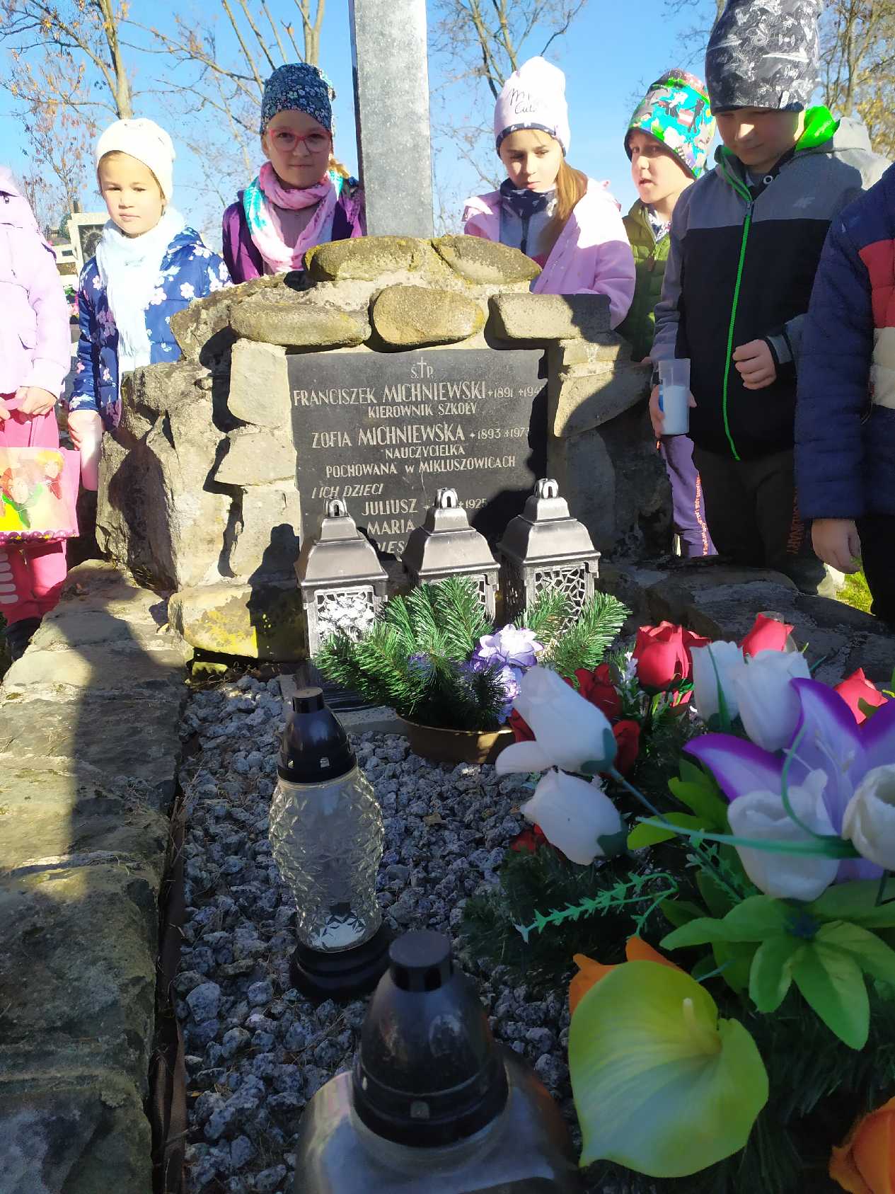 Uczniowie szkoły przy grobach zmarłych.