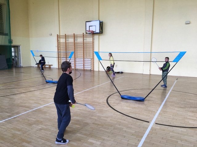 Zdjęcie przedstawia uczniów grających w badmintona.